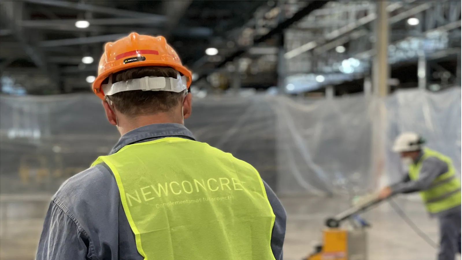 Operarios de NewConcret trabajando en el piso de hormigón de una nave industrial
